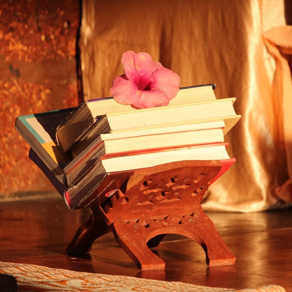 A stack of books with a flower on top.